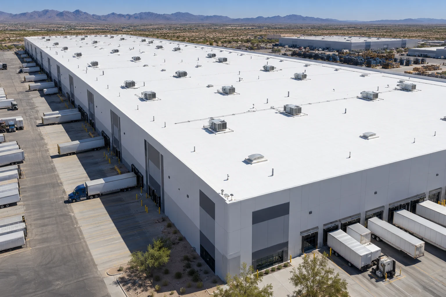 White coated warehouse roof with mechanical equipment and industrial yards